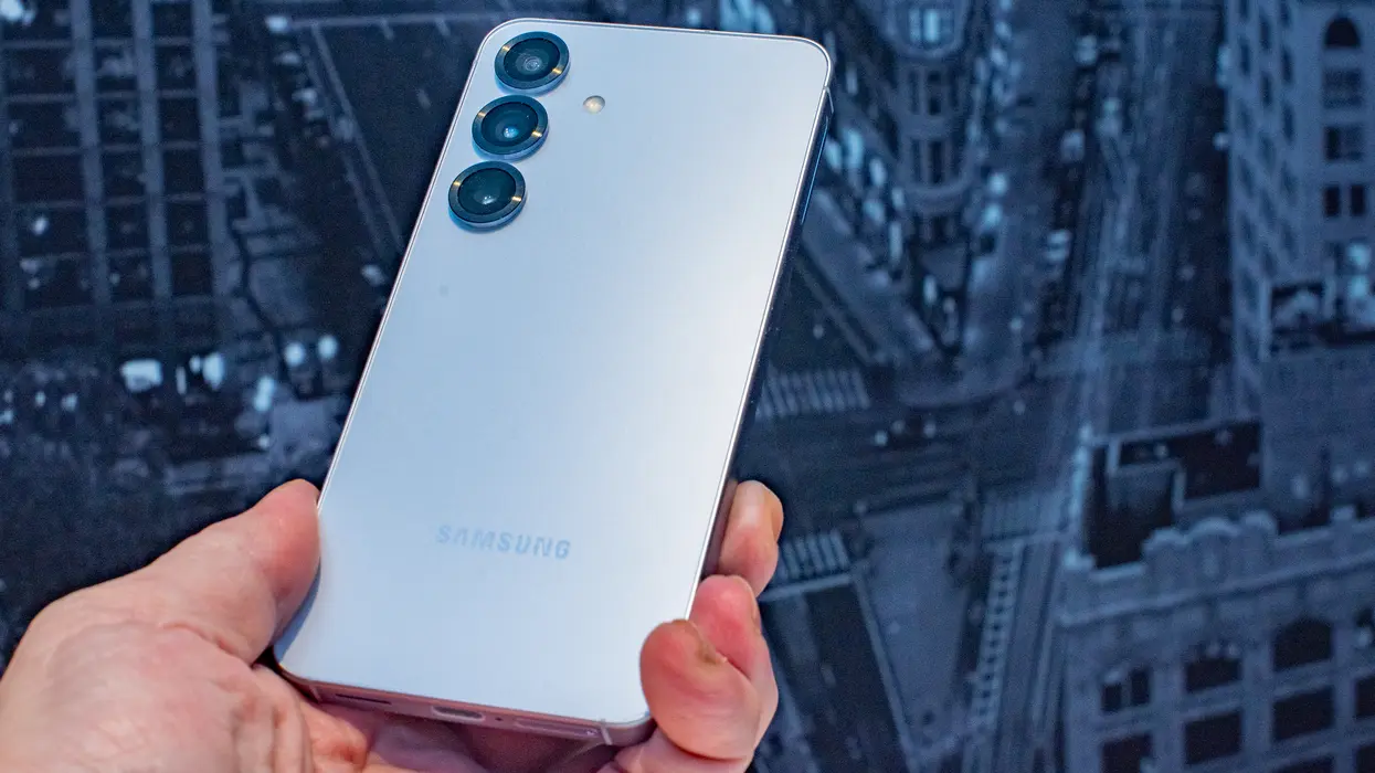 گالکسی S25 سامسونگ در دست به‌صورت زاویه‌ای که لوگوی سامسونگ را منعکس می‌کند